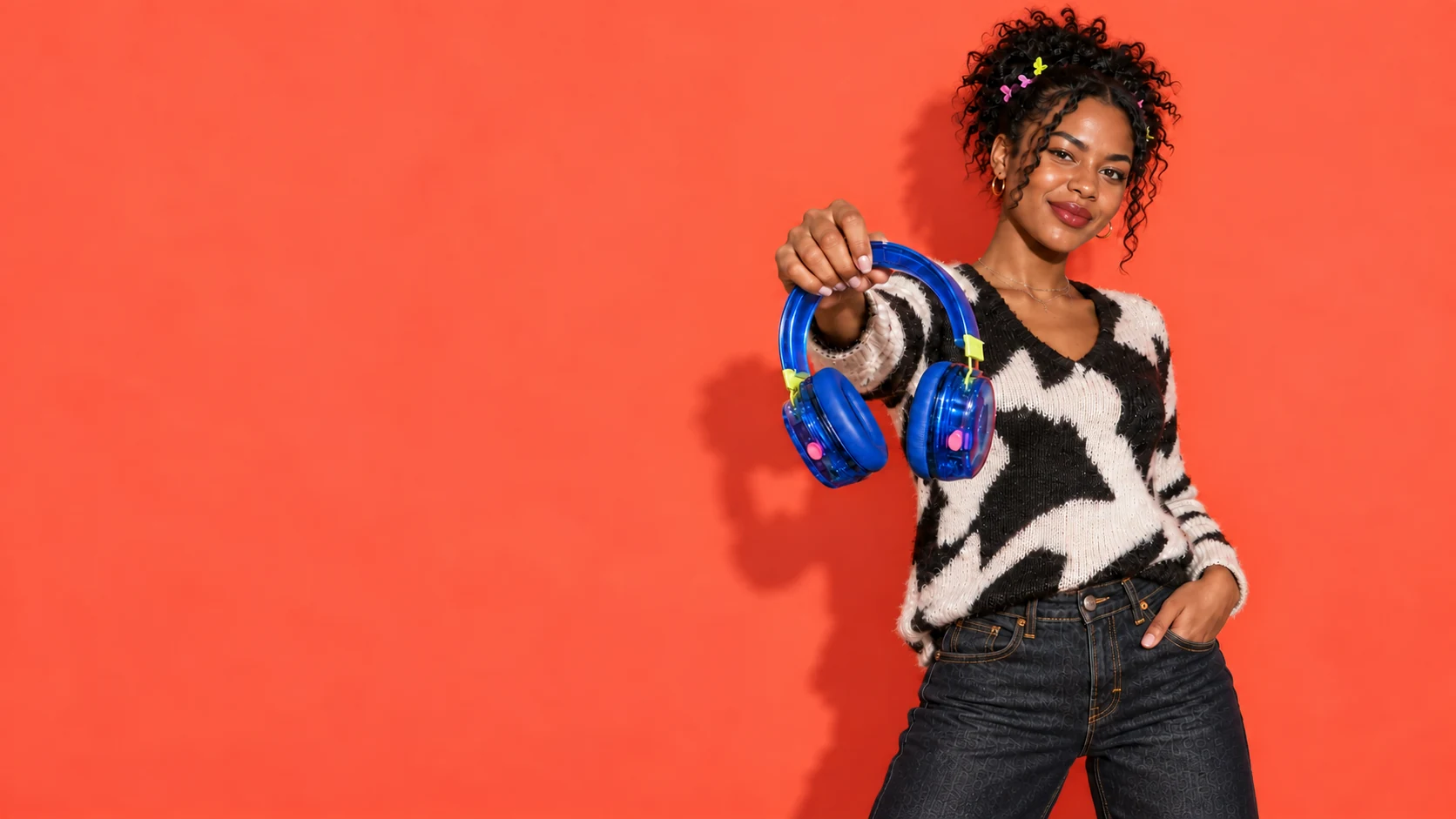 Black creator presenting translucent blue headphones toward the camera